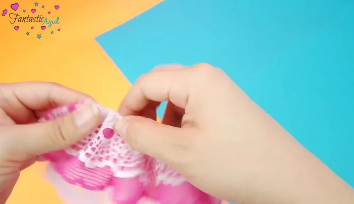 Añadir velcro y decoración (Método Manual): Acomodar uniformemente la tira. Pegar el velcro con silicón frío o con unas puntadas. Pegar las perlitas con silicón frío.