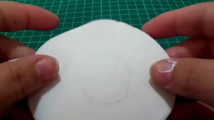 Recortar la forma de la medalla y hacer un agujero para el gancho.