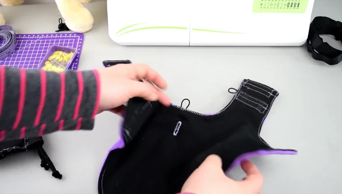 Confección de la Capucha: Coser los bordes de la capucha y agregar un cordón. Hacer ojales en el centro de la capa para una posible correa.