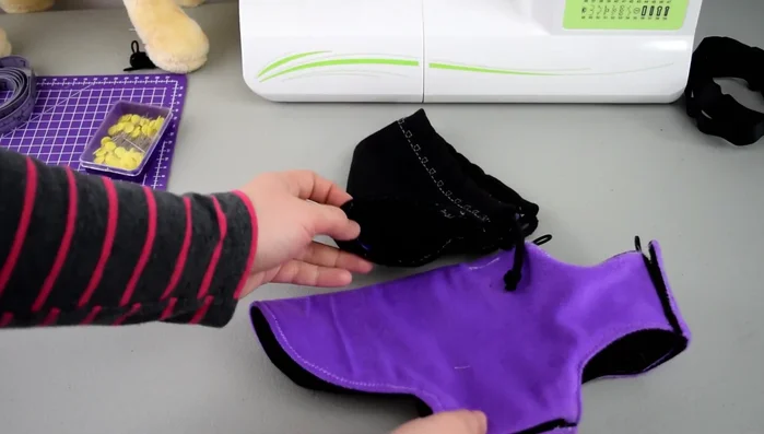 Unión de la Capucha: Cose los botones en la capucha en los mismos puntos donde están los elásticos. Une la capucha a la capa.