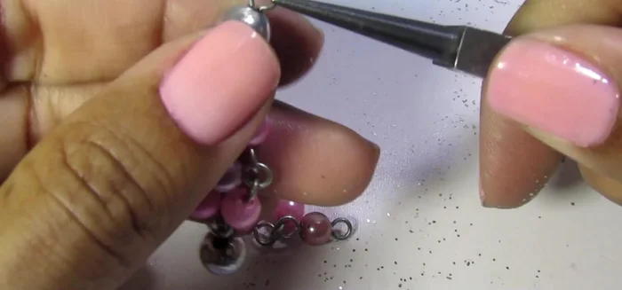 Conectar las piezas: Unir ambas piezas con un eslabón conector de plata a la cadena.