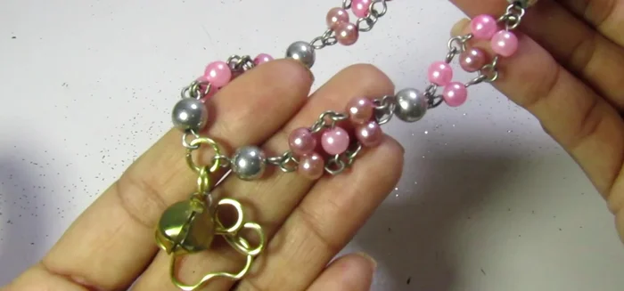 Añadir detalles finales: Agregar dos piedras plateadas a los extremos del collar para darle el toque final.