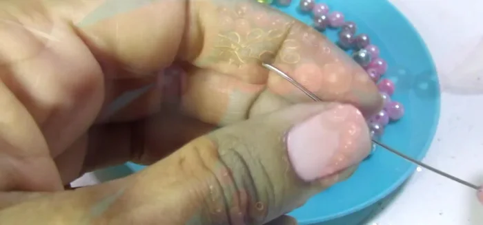 Crear los eslabones: Utilizar alambre y agregar perlitas y cristales. Primero se crea un eslabón con una piedra rosada de 1cm y dos argolas. Se repite este proceso con 20 cristales de 6mm y 8 de 8mm.