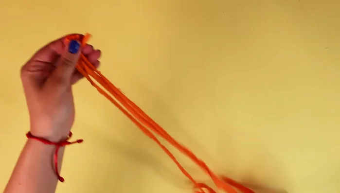 Unir las cuatro tiras con un nudo, dejando unos centímetros para los flecos.