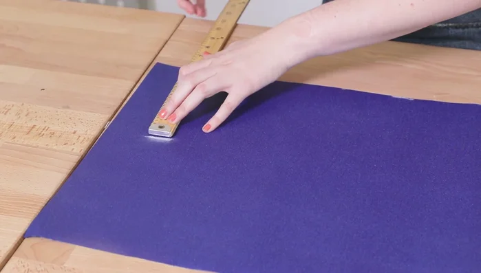 Doblar el borde sin coser 1/4 de pulgada, introducir el extremo opuesto y doblar la tira para que la costura quede en el centro, formando un cuadrado.