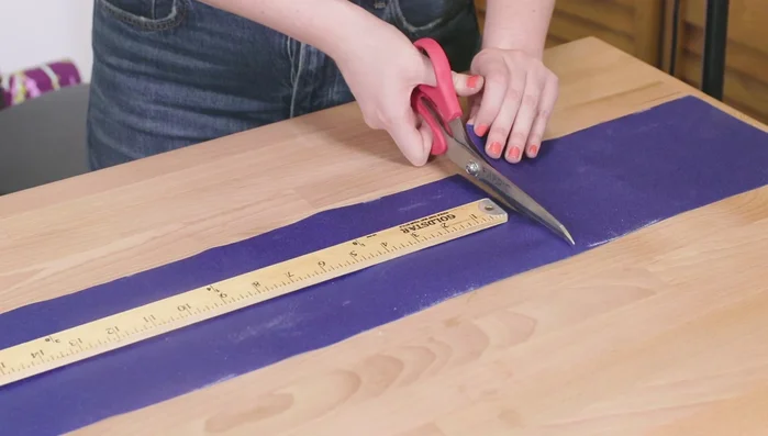 Doblar el borde sin coser 1/4 de pulgada, introducir el extremo opuesto y doblar la tira para que la costura quede en el centro, formando un cuadrado.