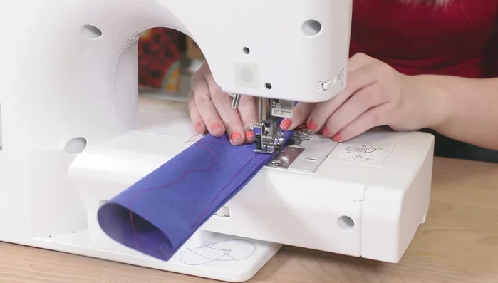 Doblar el borde sin coser 1/4 de pulgada, introducir el extremo opuesto y doblar la tira para que la costura quede en el centro, formando un cuadrado.