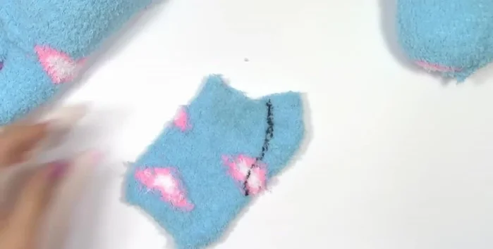 Utilizar el sobrante del calcetín para crear la cola del gatito, cosiendo y dando la vuelta.