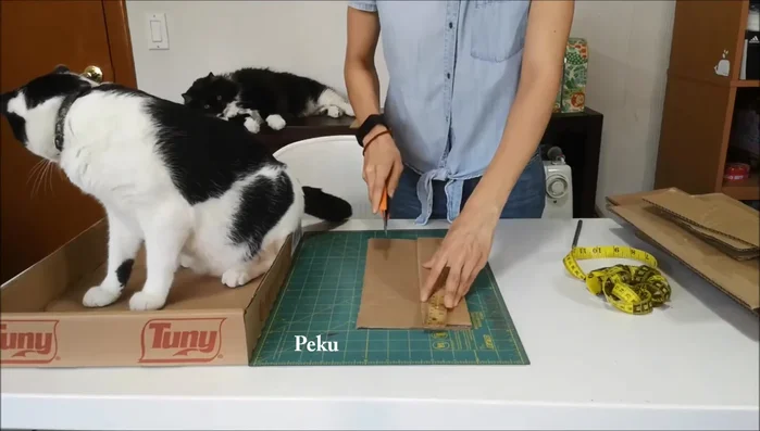 Cortar los cartones: Utilizando la muestra como guía, cortar varios cartones corrugados del mismo tamaño. Se necesitarán varias pasadas del cúter para cortar cada pieza.