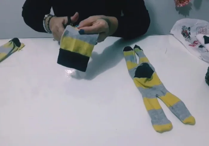 Creación de la cabeza y orejas: Cortar un semicírculo de otra parte del calcetín para formar la cabeza y las orejas. Coser y rellenar.