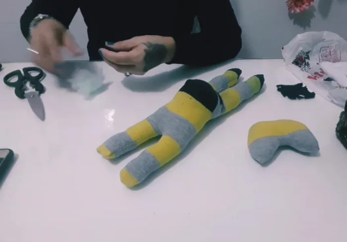 Creación de la cola: Cortar un pequeño triángulo del calcetín y rellenarlo para formar la cola. Coser los bordes.