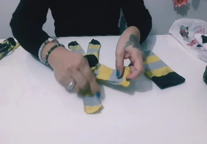 Preparación de la pieza principal: Cortar y coser la parte principal del calcetín para formar el cuerpo de la figura. Se deja un orificio para voltear la pieza.