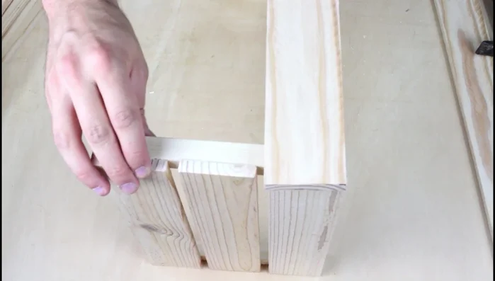 Colocar las dos piezas en vertical y pegarlas con cola blanca utilizando tablas de 480 mm para los laterales, clavando las puntas.