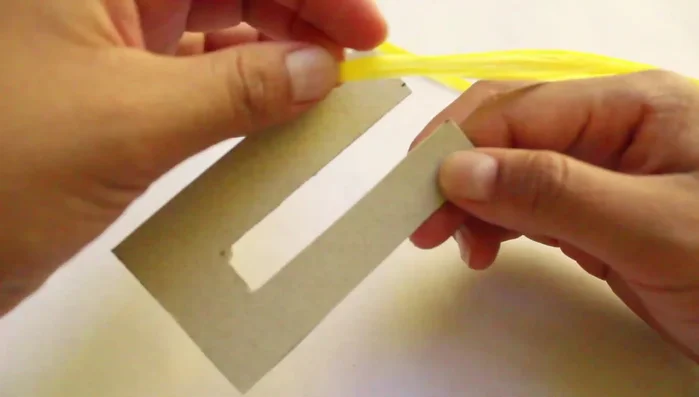 Asegurar la rafia alrededor del cartón enrollado.