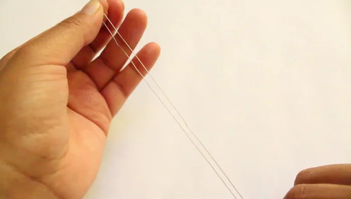 Pasar el otro extremo del hilo por medio de las chaquiras.