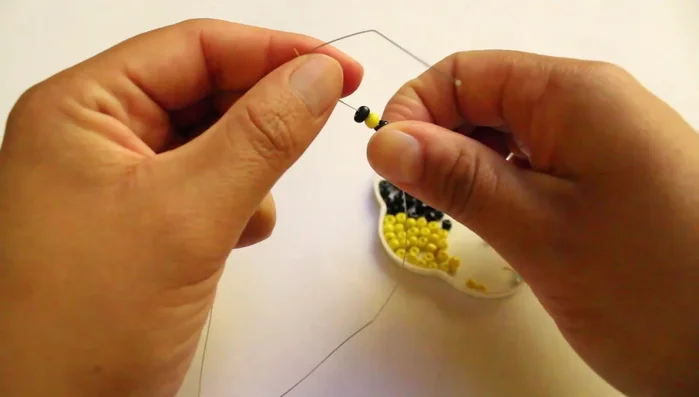 Pasar el otro extremo del hilo por medio de las chaquiras.