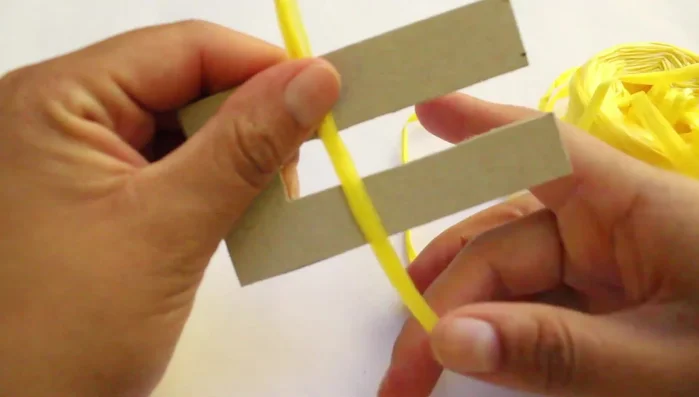 Asegurar la rafia alrededor del cartón enrollado.