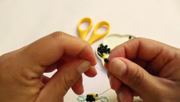 Hacer varios nudos al final para asegurar las chaquiras.