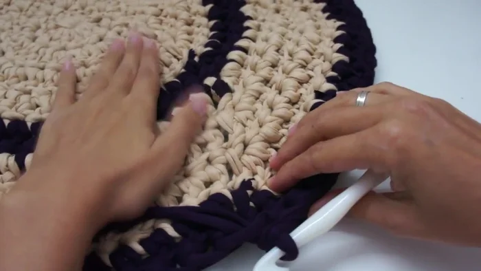 Una vez alcanzada la medida deseada para la parte frontal, tejer las orillas laterales utilizando solo la hebra interior y puntos altos, subiendo la altura con varias vueltas.