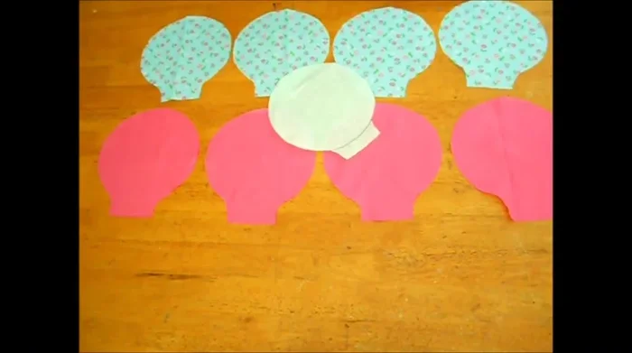 Confeccionar cuatro piezas con el patrón de la huella (dos de cada tela). Coser las dos tiras de 10 x 83 cm por los extremos para formar una banda.