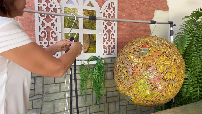 Crear el soporte de macramé: Utiliza hilo número 10 para crear un mango con nudos cuadrados. Unir los tres extremos con un nudo invisible.