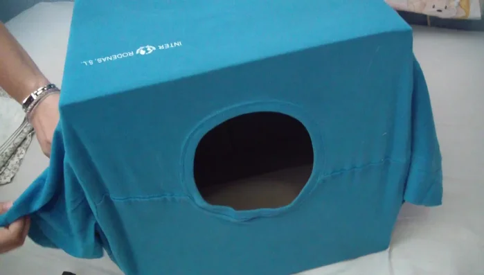 Meter las mangas: Introducir las mangas de la camiseta hacia el interior de la caja.