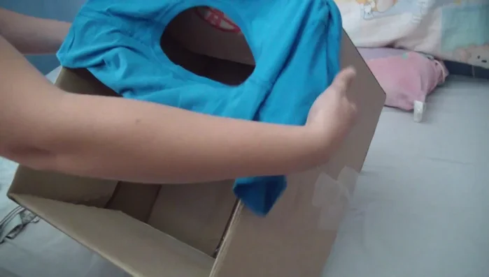 Colocar la camiseta: Introducir la camiseta (preferiblemente talla XL o una caja más grande si usas una talla L) dentro de la caja. Ajustarla para que cubra la mayor parte de la caja.