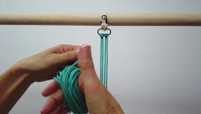 Recogida de la cuarta cuerda con goma elástica para facilitar el tejido.