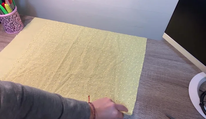 Extender la tela sobre una superficie plana y doblarla en diagonal, con los lados derechos enfrentados.