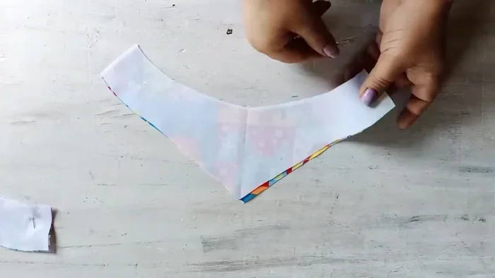 Unir las telas: Enfrenta las dos piezas de tela con los derechos juntos y únelas con alfileres (330.18). Cose alrededor, dejando un espacio abierto para voltear (336.689).