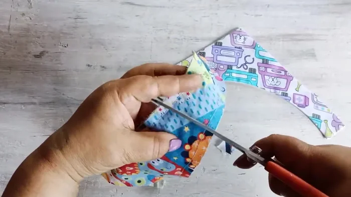 Voltear y planchar: Voltea la pieza a través del espacio abierto (470.68). Haz pequeños cortes en las esquinas para facilitar el volteo. Plancha la pieza cuidadosamente (504.33).