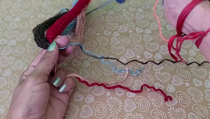 Hacer una trenza con las colas de lana de todos los cilindros.