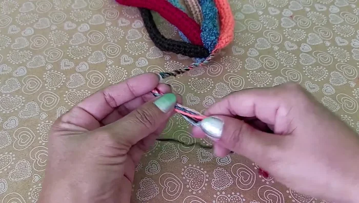 Anudar las trenzas al final para asegurarlas.