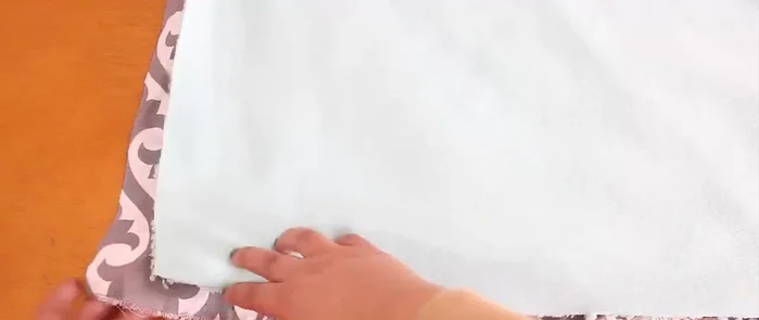 Para la cobijita, cortar una tela de loneta de tres cuartas partes del tamaño de la tela principal (ej: si la tela principal es 70x70cm, la cobijita será de 53x70cm).