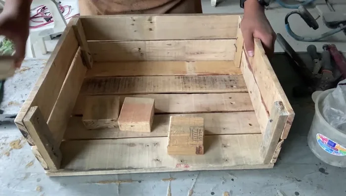 Ensamblar las patas: Fijar las piezas de madera gruesa (o doble tablita) como patas a la estructura de la cama.