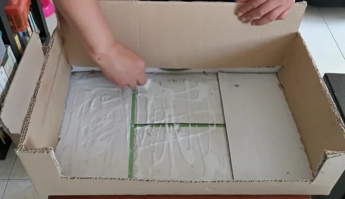 Rellenar el asiento: Pegar las tiras de cartón de huevo en la base del asiento con resistol, compactándolas lo más posible para crear un asiento firme y duradero. Sellar los bordes con más pegamento para mayor resistencia.