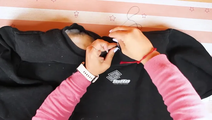 Unir el cuello de la sudadera con una puntada.
