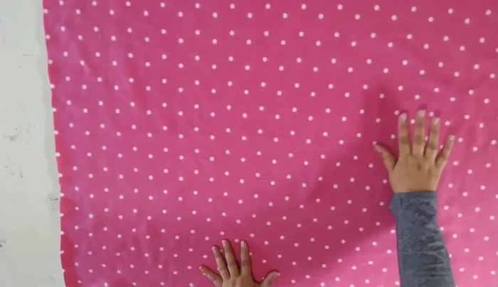 Cortar la tela siguiendo la línea recta. La parte sobrante se usará para la cola.