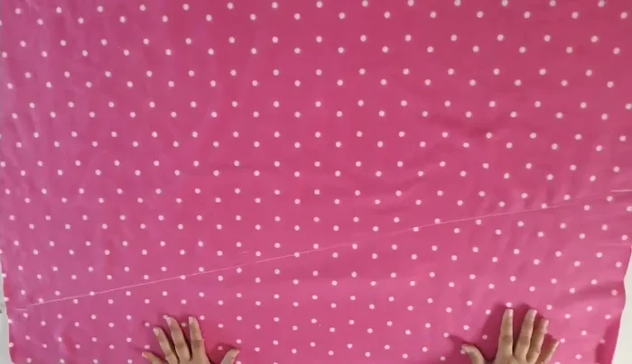 Cortar la tela siguiendo la línea recta. La parte sobrante se usará para la cola.