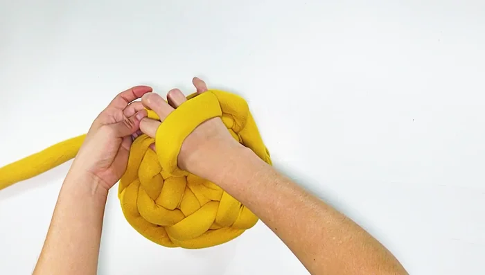 Tejer las orejitas: Jalar el hilo por un punto formando una 'orejita', luego pasar el hilo por la unión de dos puntos, jalando nuevamente. Repetir esta secuencia 23 veces.