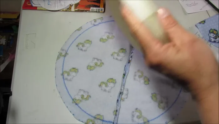 Crea el colchón: Corta un círculo de espuma o guata del mismo diámetro que la base de madera. Cúbrelo con tela suave (tela polar recomendada) y cóselo.