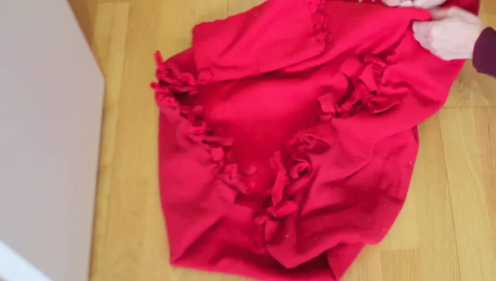 Darle la vuelta al almohadón para que los nudos queden por dentro.