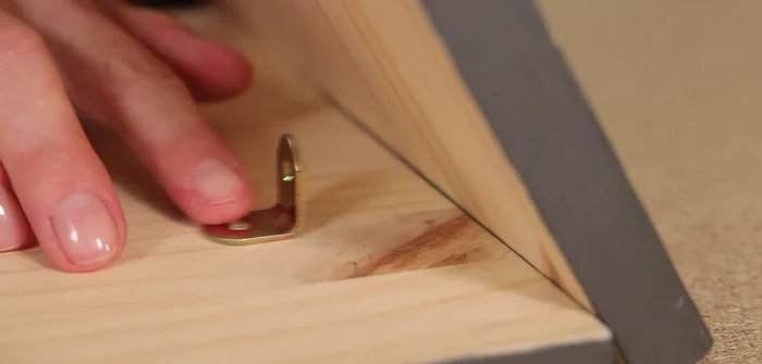 Fijar la base con cuatro escuadras, colocándolas a 5 centímetros del borde de la base.