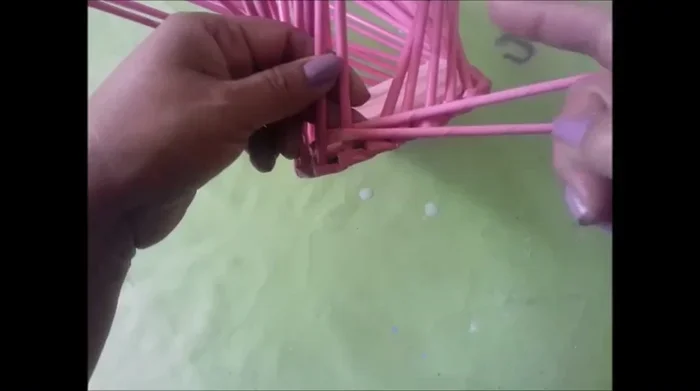 Moldear los lados: Moldear aproximadamente 2 o 4 varillas de cada lado hacia afuera en cada vuelta. Tejer las varillas del frente y atrás de manera normal.