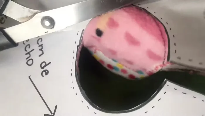 Doblar la tela para la parte del cuello y los brazos, utilizando el molde y alfileres para asegurar la forma.