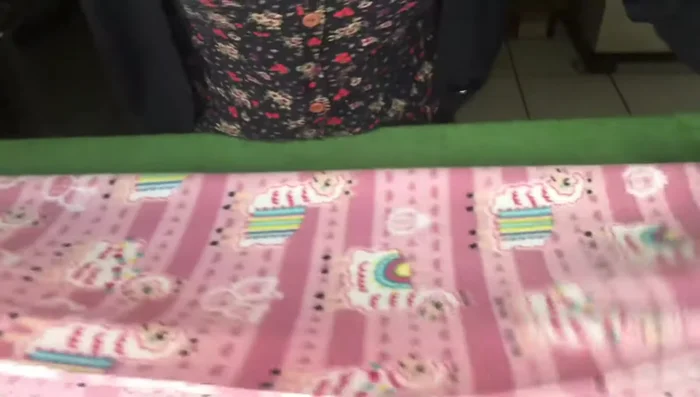 Doblar la tela para la parte del cuello y los brazos, utilizando el molde y alfileres para asegurar la forma.