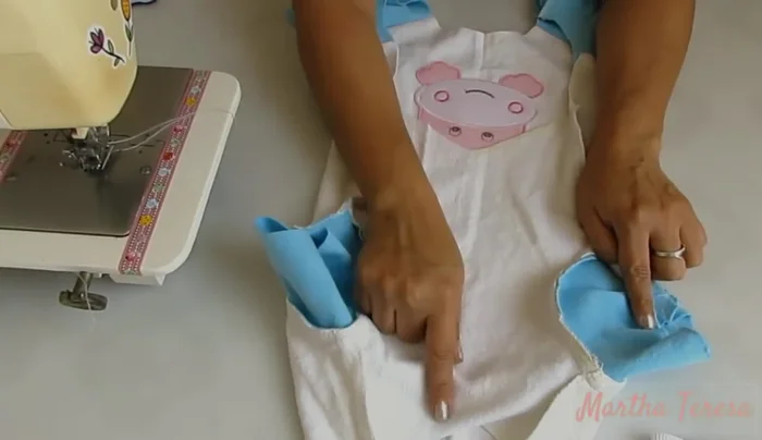 Coser los ribetes en las mangas, el cuello y el bajo del enterizo.