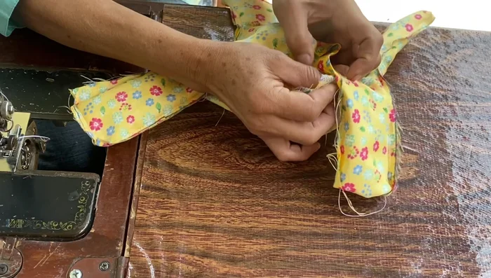 Unir la falda plisada al cuerpo del vestido, cosiendo cuidadosamente.