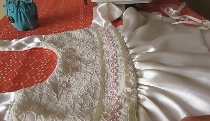 Decorar el vestido. Agregar las blondas, perlitas y lazos al vestido.