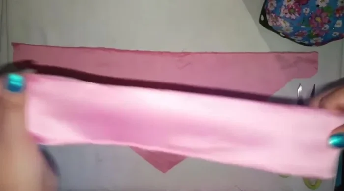 Colocar la tira del borde al frente de la pañoleta y coser a 1cm del borde. Planchar para marcar la costura y doblar la parte superior a 1cm, planchando nuevamente. Doblar a la mitad, llegando a la costura inicial. Coser a lo largo del dobladillo.